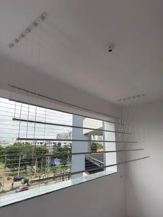 Ceiling cloth hanger with adjustable stainless steel rods installed on a Chennai balcony