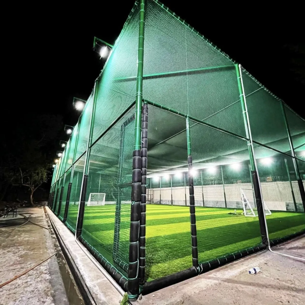 Floodlit box cricket astro turf arena with high turf nets installed by YPL Safety Nets Chennai
