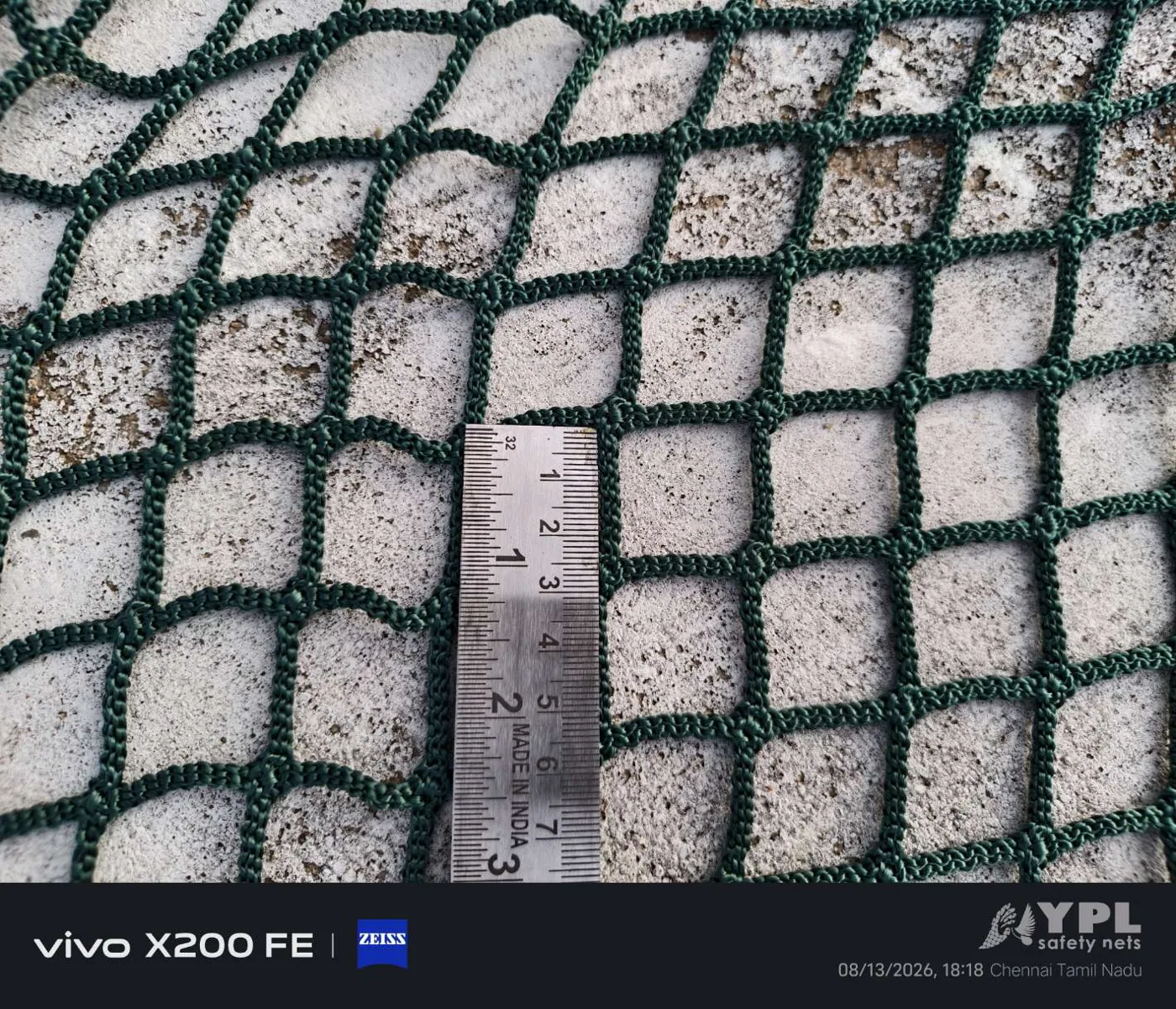 Construction safety net mesh gap measurement close-up used for fall protection netting quality checks