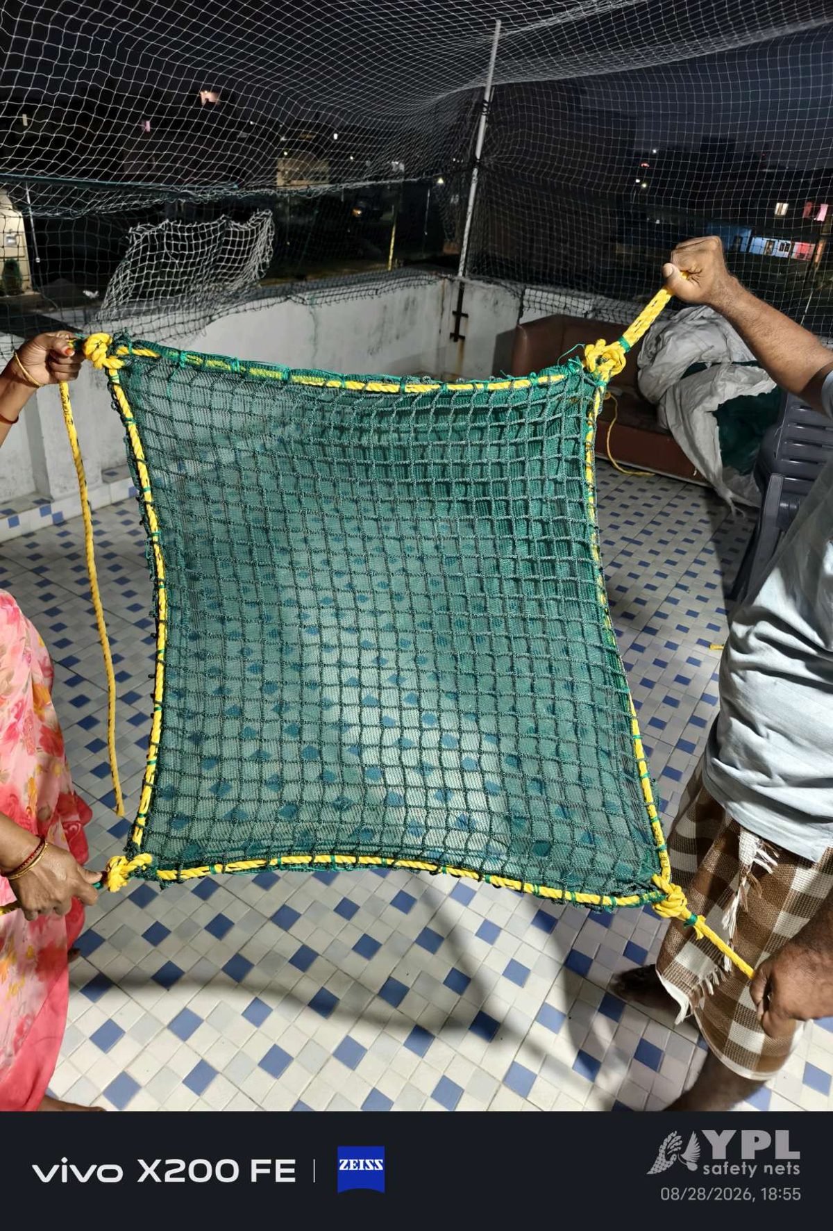 Knotless nylon construction safety net panel with yellow PP rope border held open by the YPL Safety Nets team before dispatch to a Chennai building site