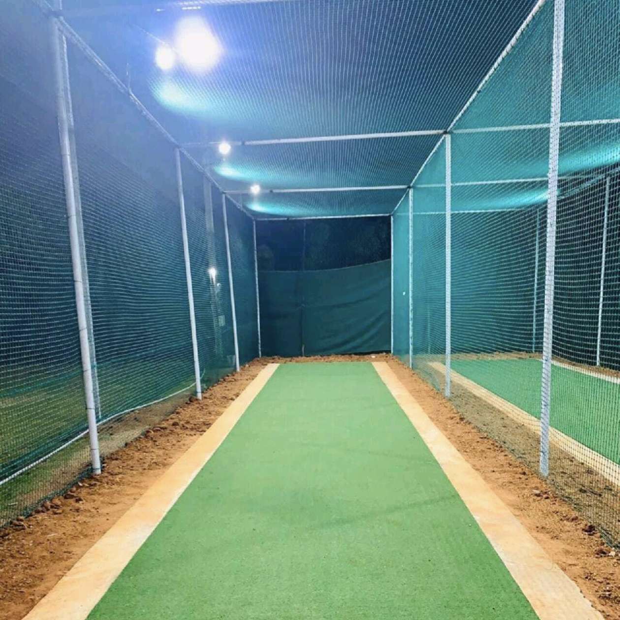 Floodlit cricket practice net lane with turf pitch and green HDPE netting by YPL Safety Nets