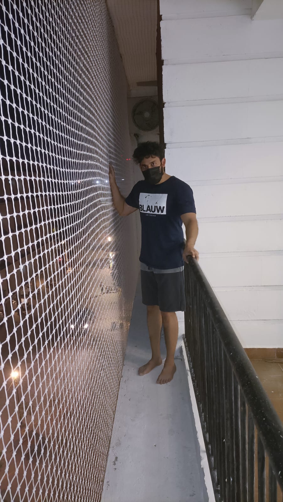 White knotted balcony safety net strength-tested by hand at a Chennai apartment installation by YPL Safety Nets